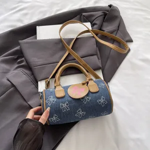 Chic denim pillow handbag with stylish bow print, comfortable handle and strap for daily wear.
