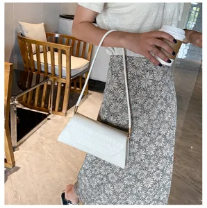 Detailansicht der weißen Krokodilmuster Baguette Umhängetasche, perfekt für den Alltag.