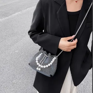 Detailed view of the sparkling rhinestone bucket bag with elegant pearl handle and chain strap.