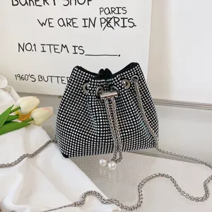 Sparkling rhinestone bucket bag detail featuring glittering crystals and pearl chain strap.