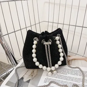 Black rhinestone bucket bag with pearl handle and metal chain shoulder strap for women.