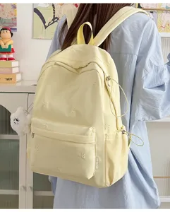 Detailed view of the cute yellow student backpack featuring delicate bow embroidery and casual style.
