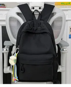 Detailed view of the black backpack featuring gothic embroidery, front pocket and side pendant.