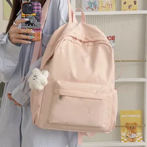Korean style cute pink school backpack with bow embroidery and plush bear pendant for students.