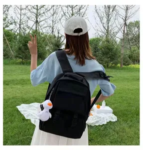 Black casual backpack detail view featuring a cute white duck pendant for daily use.