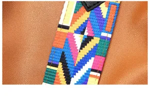 Close-up view of women handbag shoulder strap featuring vibrant colorful ethnic geometric pattern.
