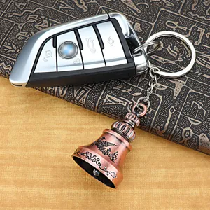Vintage retro car key keychain with bronze bell pendant, stylish metal keyring accessory.