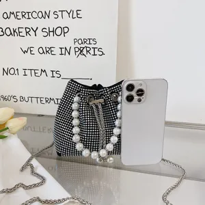 Rhinestone pearl bucket bag detail shot, sparkling crystal handbag with elegant pearl handle.