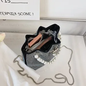 Black rhinestone pearl bucket bag detail showing sparkling crystals and chain strap capacity.