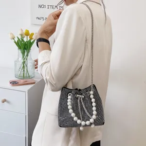 Fashionable black rhinestone bucket bag with pearl handle and silver chain strap for women.