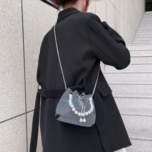 Rhinestone bucket bag detail showing sparkling mesh fabric and elegant pearl handle design.