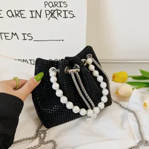 Detailed view of black rhinestone bucket bag featuring elegant pearl handle and metal chain strap.