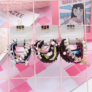 Detail shot of cute pearl decorated hair ties set with hanging cards for daily styling.