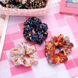 Vue détaillée de chouchous à fleurs en mousseline, jolis accessoires de coiffure.