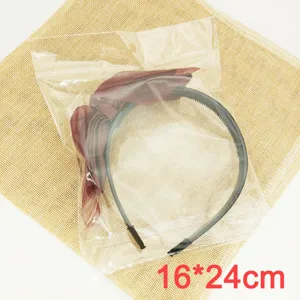 Clear OPP self-adhesive packaging bag with black headband and wine red bow for accessories.