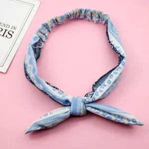 Primer plano detallado de la diadema de gasa floral azul con un lazo suave y elegante.