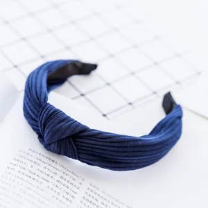 Detailed close-up of blue pleated headband showcasing soft fabric texture and knot design.