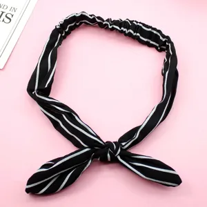 Detalle de la diadema de rayas blancas y negras, mostrando el dulce nudo de lazo y tela suave.