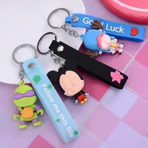 Close-up detail of cute cartoon silicone keychains with colorful straps and character pendants.