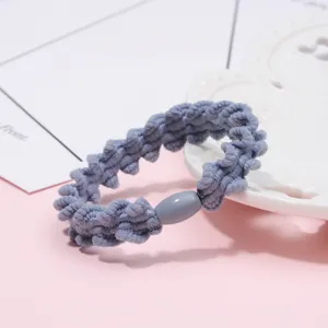 Close-up detail of wavy braided elastic hair tie, textured hair band for daily styling.