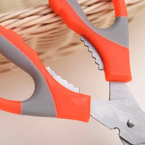 Close-up detail view of multi-purpose kitchen scissors with ergonomic orange handle.