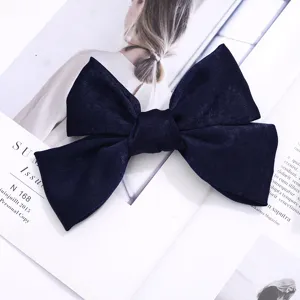 Primer plano de una elegante pinza de pelo con lazo de terciopelo azul oscuro, textura delicada.