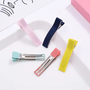 Gedetailleerde weergave van halfomwikkelde lint alligator haarspelden voor DIY haaraccessoires.