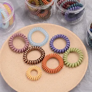 Colorful plastic telephone wire hair ties set with clear storage jars and display tray.