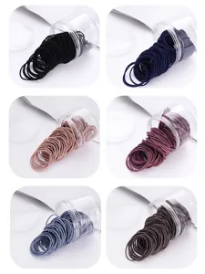 Close-up detail of assorted color hair ties in clear plastic storage jars, high stretch.
