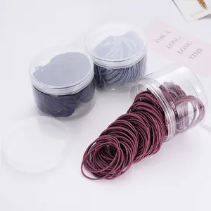 Detail view of boxed elastic hair ties in clear jars, assorted colors for daily hairstyles.