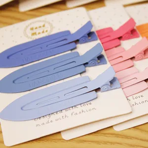 Close-up detail view of pastel blue and pink duckbill hair styling clips on card packaging.