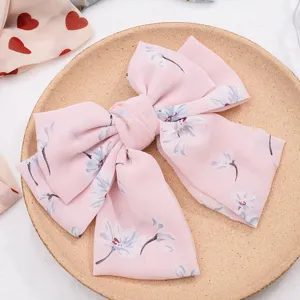 Chiffon floral hair bow clip detail view, elegant pink hair accessory for women and girls.
