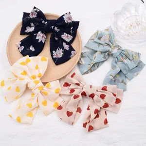 Details of chiffon large bow hair clips featuring sweet floral and heart prints for cute hair styling.