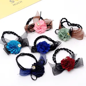 Detailed close-up view of colorful fabric flower hair ties with mesh bows and sparkling rhinestones.