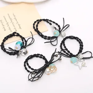 Detailed view of fashionable black hair ties with pearl, star and bow charms for women.