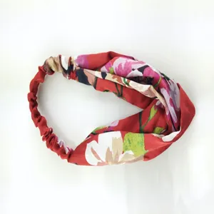 Gedetailleerd overzicht van de rode bloemen satijnen elastische haarband met zachte textuur.