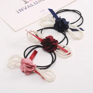 Elegant pearl flower hair tie with fabric camellia and ribbon bow, perfect for daily styling.