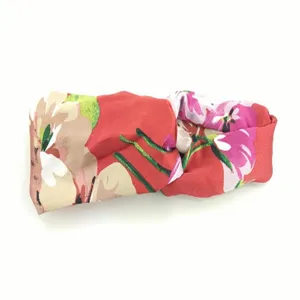 Detailopname van de rode geranium bloem patroon zijde satijn kruis haarband stof.