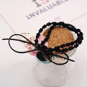 Chic black hair scrunchie with gold hollow leaves and fabric flowers, stylish floral hair tie.