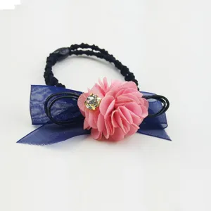Close up detail of hair tie with blue mesh bow, pink flower and sparkling rhinestone.