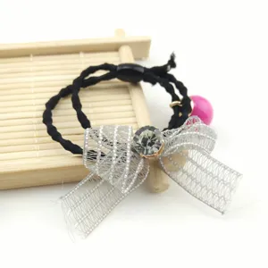 Detailed close-up of a black hair tie featuring a silver mesh bow and crystal rhinestone.