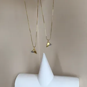 Goldfarbene Partnerkette mit magnetischen Herzanhängern, elegante Schmuck Detailansicht.