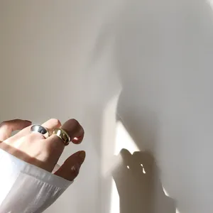 Minimalistischer Detailshot gewölbter Ringe, glatter Metall Fingerring in zweifarbiger Optik.