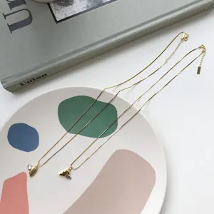 Nahaufnahme von zarten goldenen Herz-Anhänger-Halsketten auf einem künstlerischen Keramikteller.