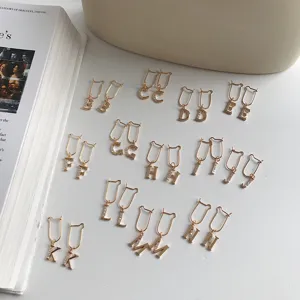 Eleganti orecchini pendenti con lettere dell'alfabeto placcati in oro e zirconi.