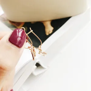 Orecchini a cerchio con ciondolo lettera H in argento S925 oro rosa, design minimalista.