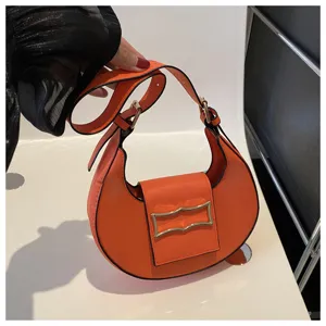 Orange crescent shoulder bag for women, stylish underarm hobo bag with metal buckle.