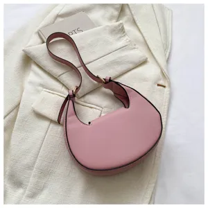 Pink crescent shoulder bag detail, stylish underarm hobo purse with metal hardware and strap.