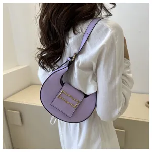 Stylish lavender crescent shoulder bag worn by model, showcasing trendy niche design and chic hardware.