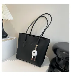 Black large capacity shoulder tote bag with cute plush charm and embossed pattern for daily commute.